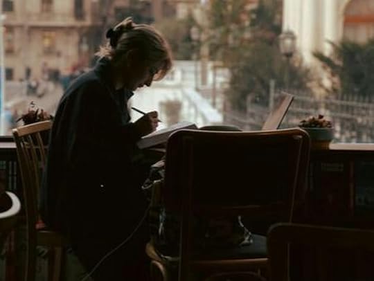 An author writing in a café, capturing the essence of crafting a novella with a compelling hook—an essential step in engaging readers from the first page.