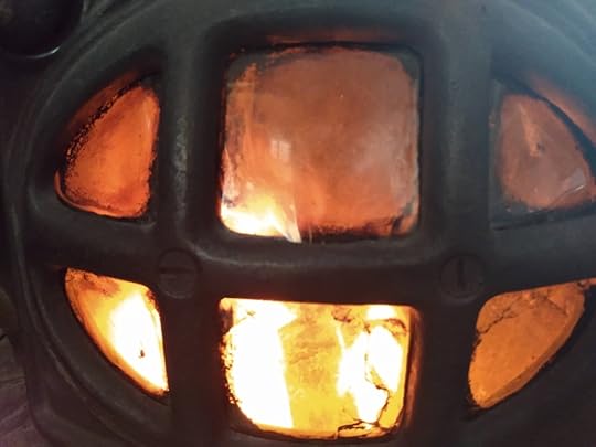 Photo of fire behind the mica windows of a coal burning stove.