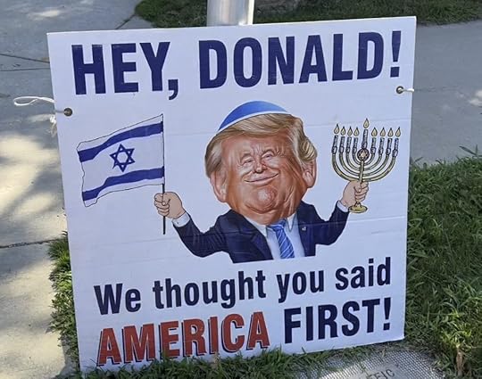 a sign showing former President Donald Trump waving an Israeli flag in one hand anda Hanukah menorah in the other while wearing a kippah--a traditional Jewish headcovering worn during prayer. Text reads 