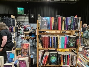 Photo of a book rack on a dealers table, with the cover of 
