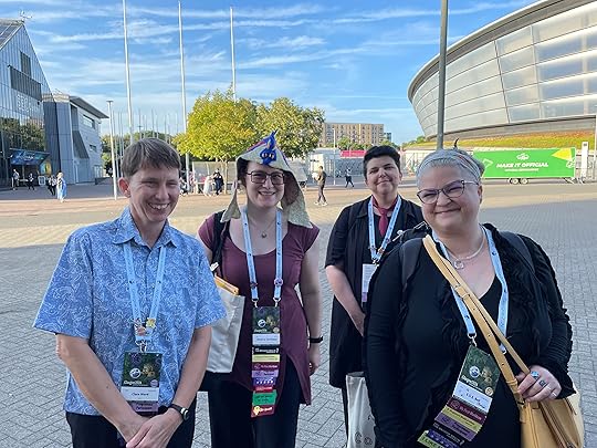 Photo of 4 smiling people with Worlcon badges