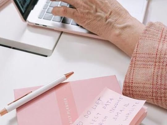 Hands typing on a laptop with a to-do list in the background, symbolizing the steps involved in structuring a novella.