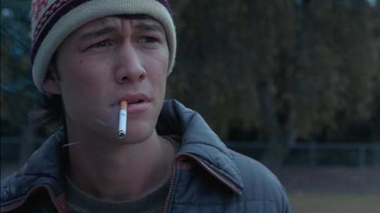 An image of Joseph Gordon Levitt in the film adaptation of Mysterious Skin. Levitt looks stricken and upset, he's wearing a wool hat and has a cigarett dangling from his lips