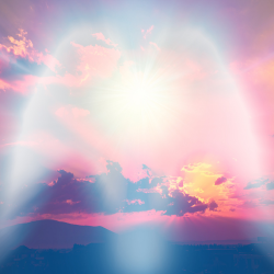 Angelic silhouette of light on a pink and gold sunset sky with billowy clouds