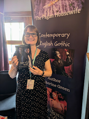 Photo of paranormal author Catherine Green holding her new book “Bite of the Wolf (A Redcliffe Novel)” at Books on the Beach in Blackpool book signing event. Vampire writer and LGBT fantasy book writer.