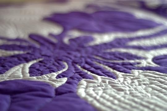 Detail of blue and white floral quilt pattern.