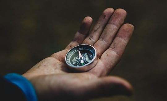 A hand holding a compass