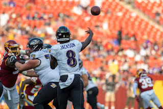 Lamar Jackson of the Baltimore Ravens throws a football downfield