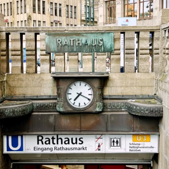 Uhr und Schild an der Treppe, die hinab zur U3 am Rathausmarkt führt
