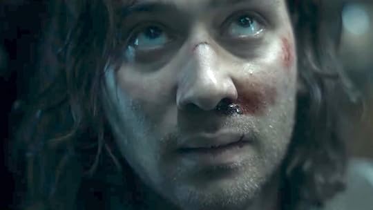 Maxim Baldry battered and on the ground looking up as Isildur on The Rings of Power