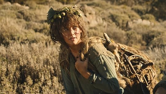 Nori walking outside in the desert with a bag on her back during the day on The Rings of Power
