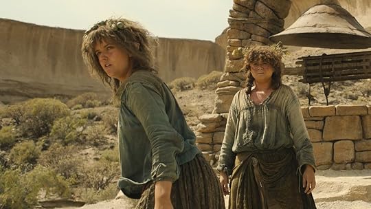 Nori and Poppy outside in the desert during the day looking out at the horizon on The Rings of Power