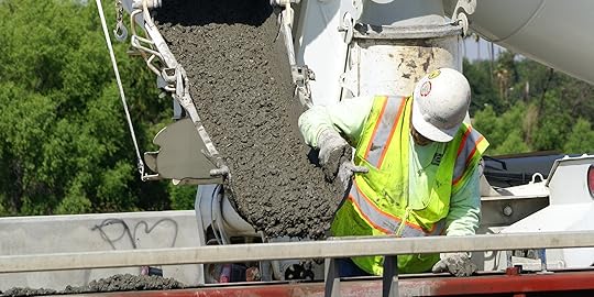workman pouring cement from a truck