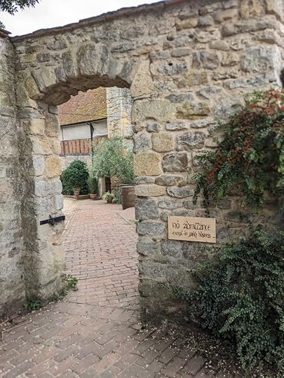 An open gateway in a stone wall. A sign to the right reads 'No Admittance Except on Party Business'
