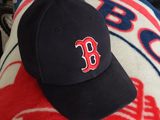 Image of a baseball cap for the Boston Red Sox. A red letter 'B' set against a dark blue colored cap