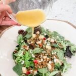 The finished Fall Apple and Gorgonzola Salad having dressing poured over it