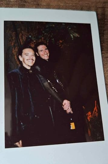 Instant photo showing two white men with long dark hair, smiling and dressed in black