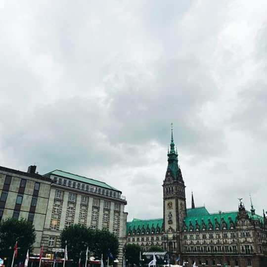 Das Hamburger Rathaus, aus den Arkaden heraus aufgenommen, unter typisch grauem Himmel und hohen Wolken