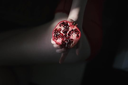 person holding red pomegranate