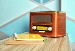 Image of a an old fashioned radio with a writing pad beside it
