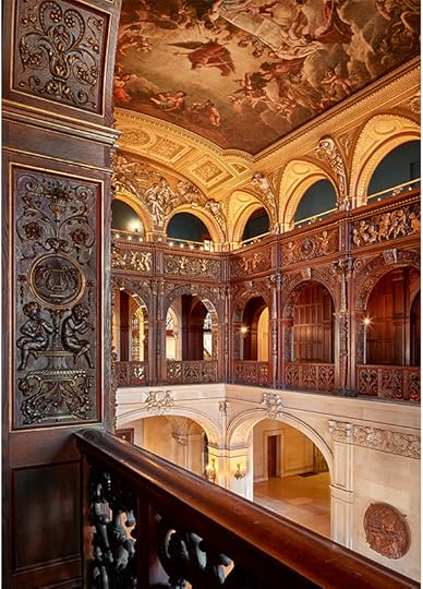 Color photo of an ornate, Beaux Arts two-story hllway, whith arched openings and a classical mural on the ceiling