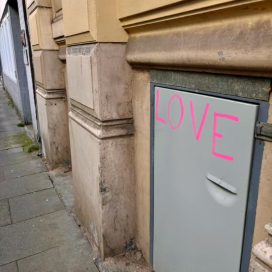 Das Wort Love auf der Tür zu einem Kabuff für Mülleimer in einer Hauswand