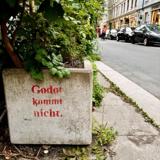 Ein Pflanzkübel aus Beton an einem Straßenrand, in roter Farbe aufgesprüht: 