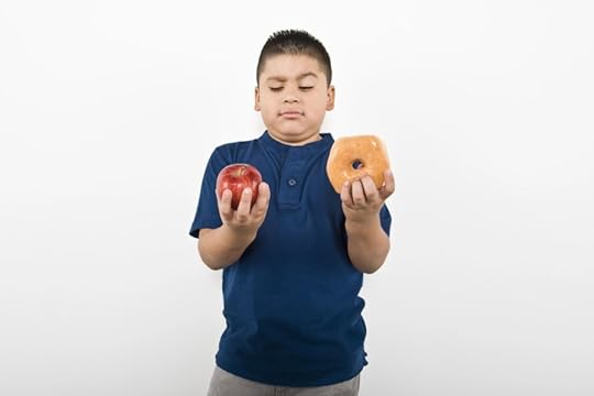boy choosing between healthy apple and unhealthy donut