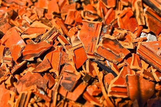 A pile of broken red roof tiles.