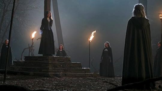 Agatha Harkness tied to a stake as a coven of witches surrounds her at night in the woods