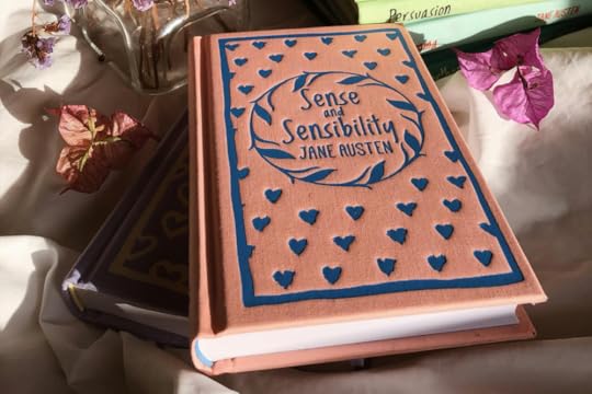 Image: a clothbound edition of Jane Austen's Sense and Sensibility is arranged with other books and dried flowers.