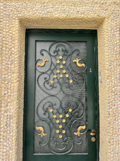 Décoration de coquillages autour d'une porte ouvragée