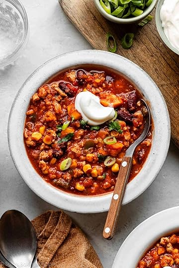 bowl of sweet potato turkey chili with spoon in it and topped with a dollop of sour cream.
