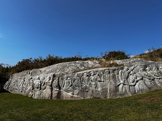 A row of fishermen carved in granite