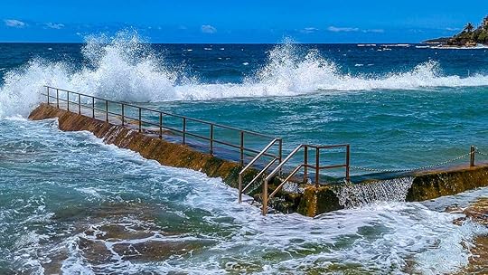 Ocean pool with wave breaking over the side filling the pool with fresh seawater.