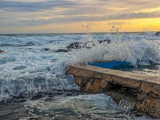 A wave breacking against the side of a rock pool. 