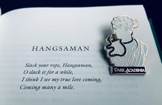 The opening page of Shirley Jackson's novel Hangsaman. On the page sits a pin with a classical bust, a snake, and the words "Dark Academia" on it.