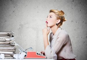 Woman deep in thought at her typewriter