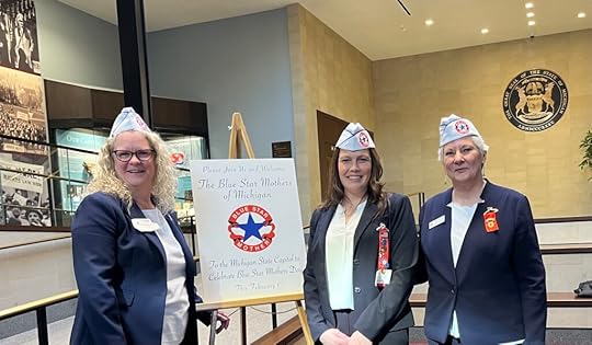 Three women standing with a sign for the Blue Star Mothers of Michigan