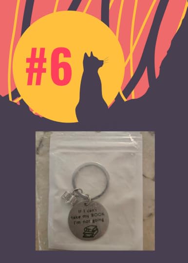 A black cat sits in front of a moon, and the keychain and book charm are displayed.