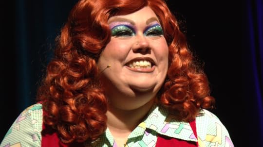 A drag queen in red wig smiles as she performs in Drag Heals season 4.