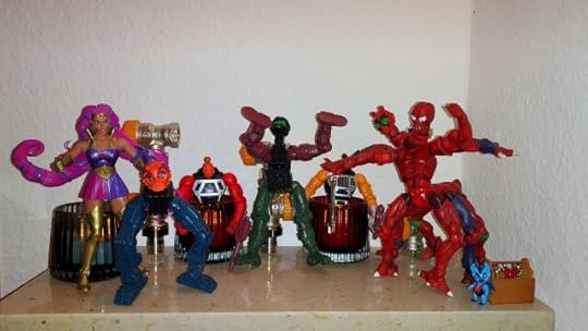 Entrapta has added a second pair of legs as arms to one robot, much to Modulok's annoyance. Imp still looks on.