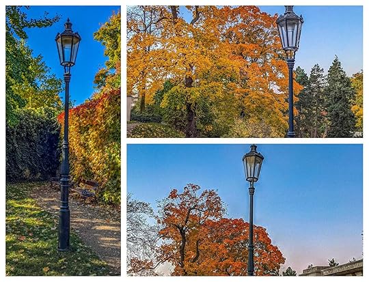 Three lampposts in Grebovka Park in front of fall trees. 