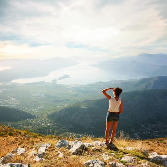 A traveler standing at the edge of a cliff, looking toward the distant horizon