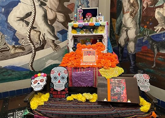 A brightly colored table and displayof sugar skulls, flowers and figurines. 