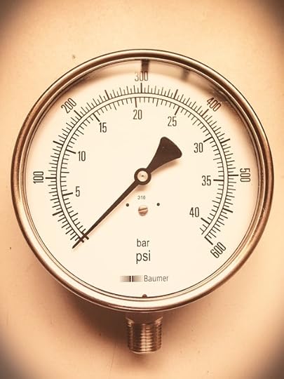 Pressure gauge against a taupe, soft focus background