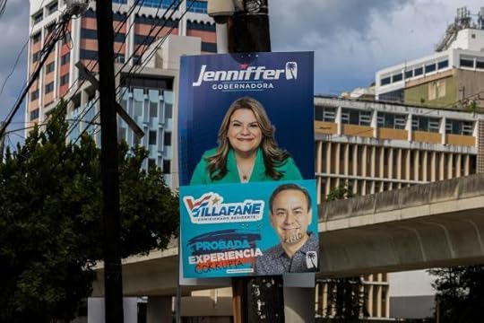 A campaign poster promotes New Progressive Party gubernatorial candidate and Puerto Rico's representative in Congress Jenniffer González, above a campaign poster of resident commissioner candidate Luis Villafañe, defaced with the Spanish words for corrupt and rogue