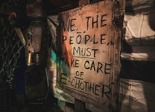 A sign that reads “We the people must take care of each other.” Change and positivity.