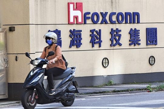 © Reuters. FILE PHOTO: A woman drives past the Foxconn logo outside the company's building in Taipei, Taiwan, November 9, 2022. REUTERS/Ann Wang/File Photo