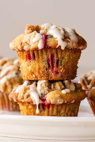 stack of 2 cranberry crumb orange muffins with icing on top.